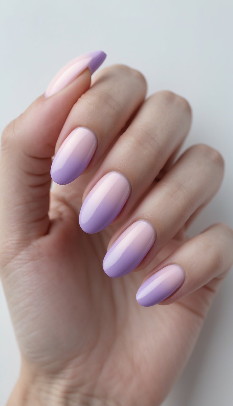 Close-up of one hand with ombre gradient nails transitioning from pink to lavender on a white background.