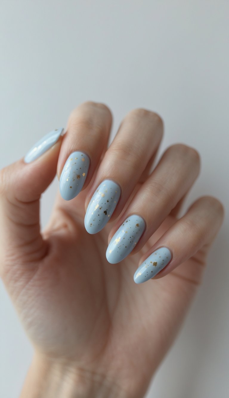 Close-up of one hand with baby blue nails decorated with small gold specks against a white background.