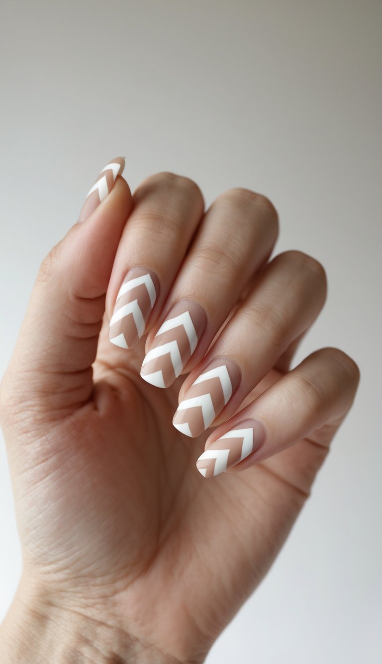 Close-up of one hand showing nails with a simple chevron pattern on a white background.
