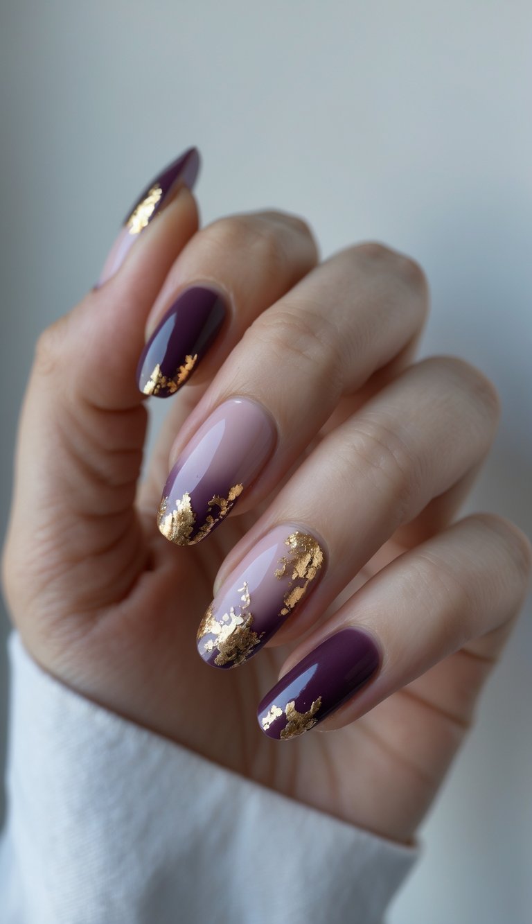 Close-up of one hand with plum ombre nails decorated with gold foil on a white background.