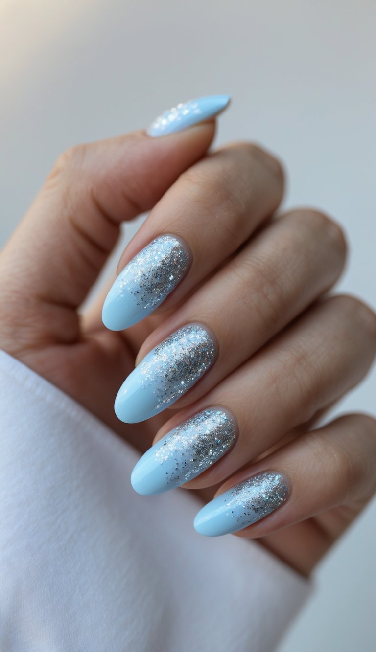 Close-up of a hand with baby blue nails decorated with silver glitter on a white background.