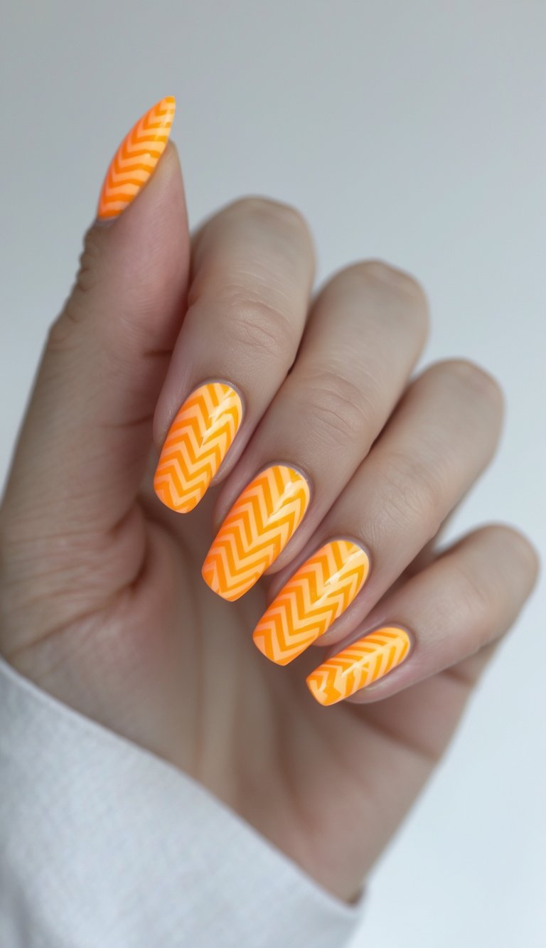 Close-up of a hand with neon orange chevron nail art on manicured nails against a white background.