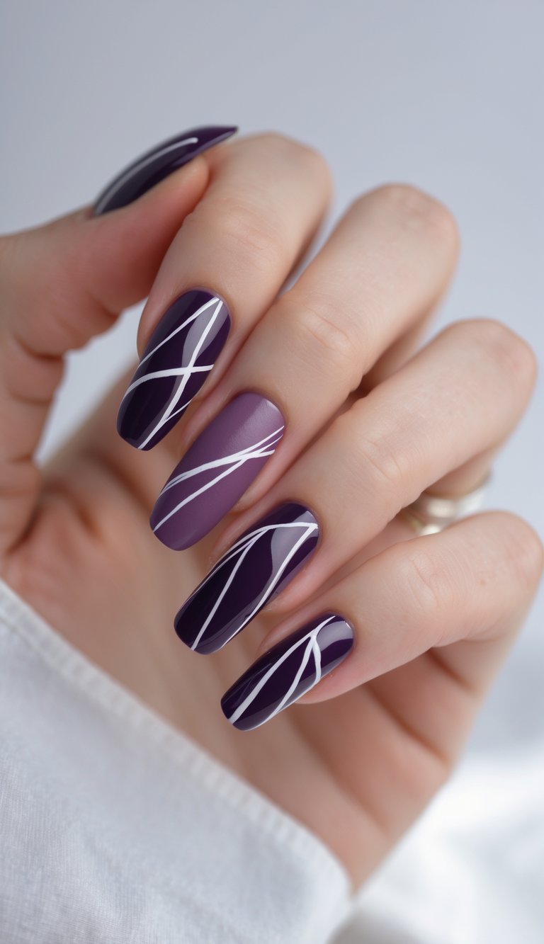 Close-up of one hand with dark purple nails featuring abstract line designs against a white background.