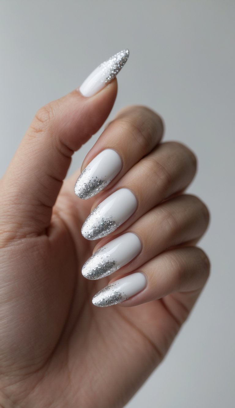 Close-up of one hand with white nails and silver glitter tips against a white background.