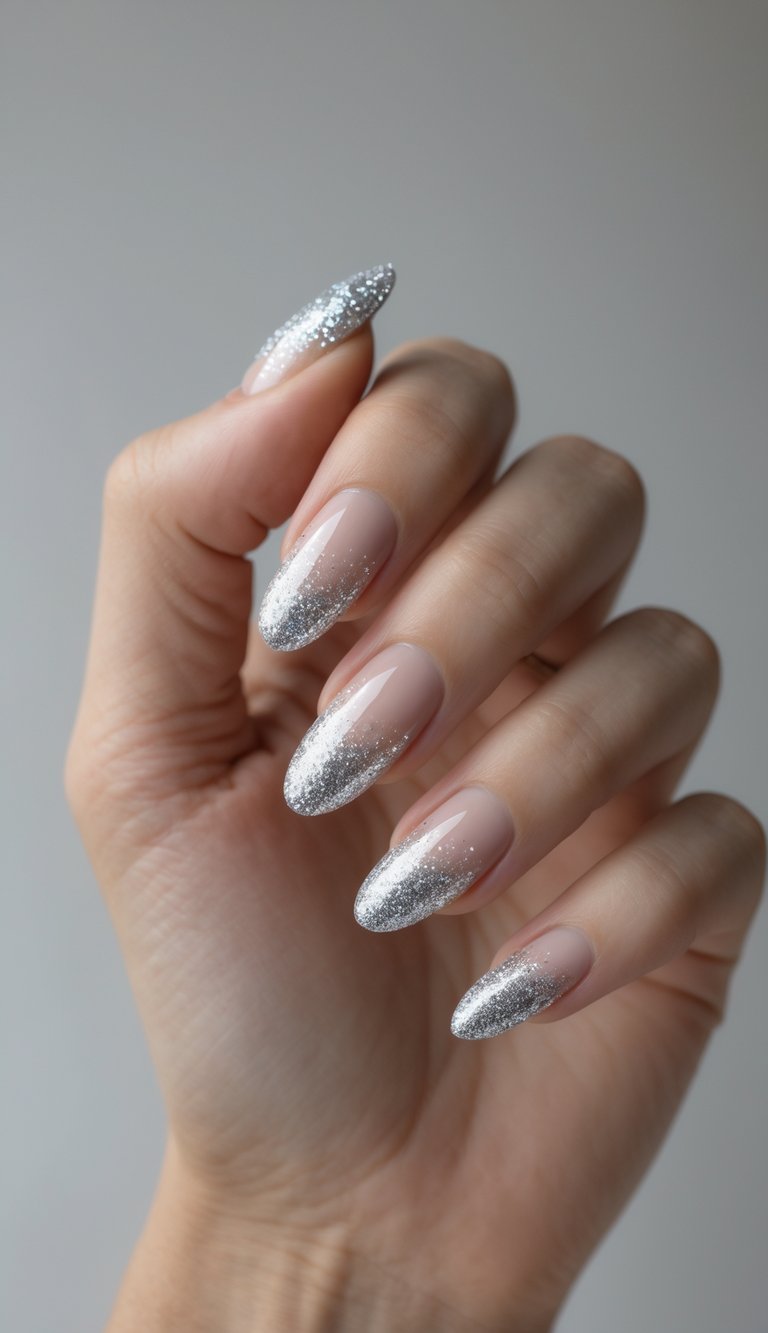 Close-up of one hand with silver glitter fade tip manicure against a white background.