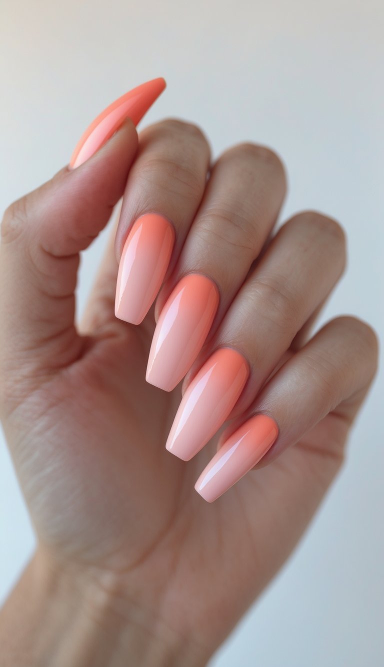 Close-up of a hand with long tapered nails painted in coral and pink gradient on a white background.