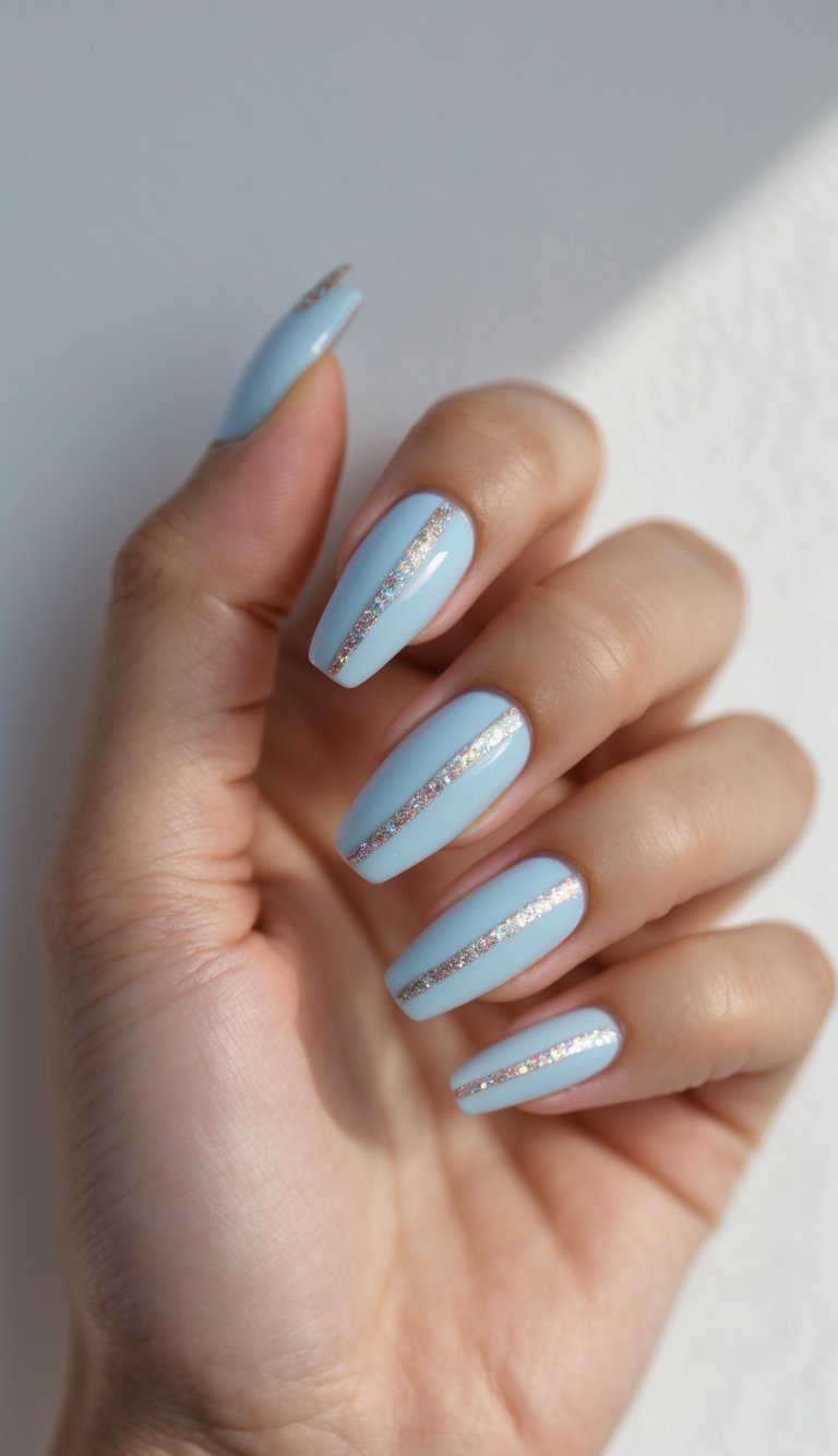 Close-up of one hand with ballerina-shaped nails painted pastel blue with glitter stripes on a white background.