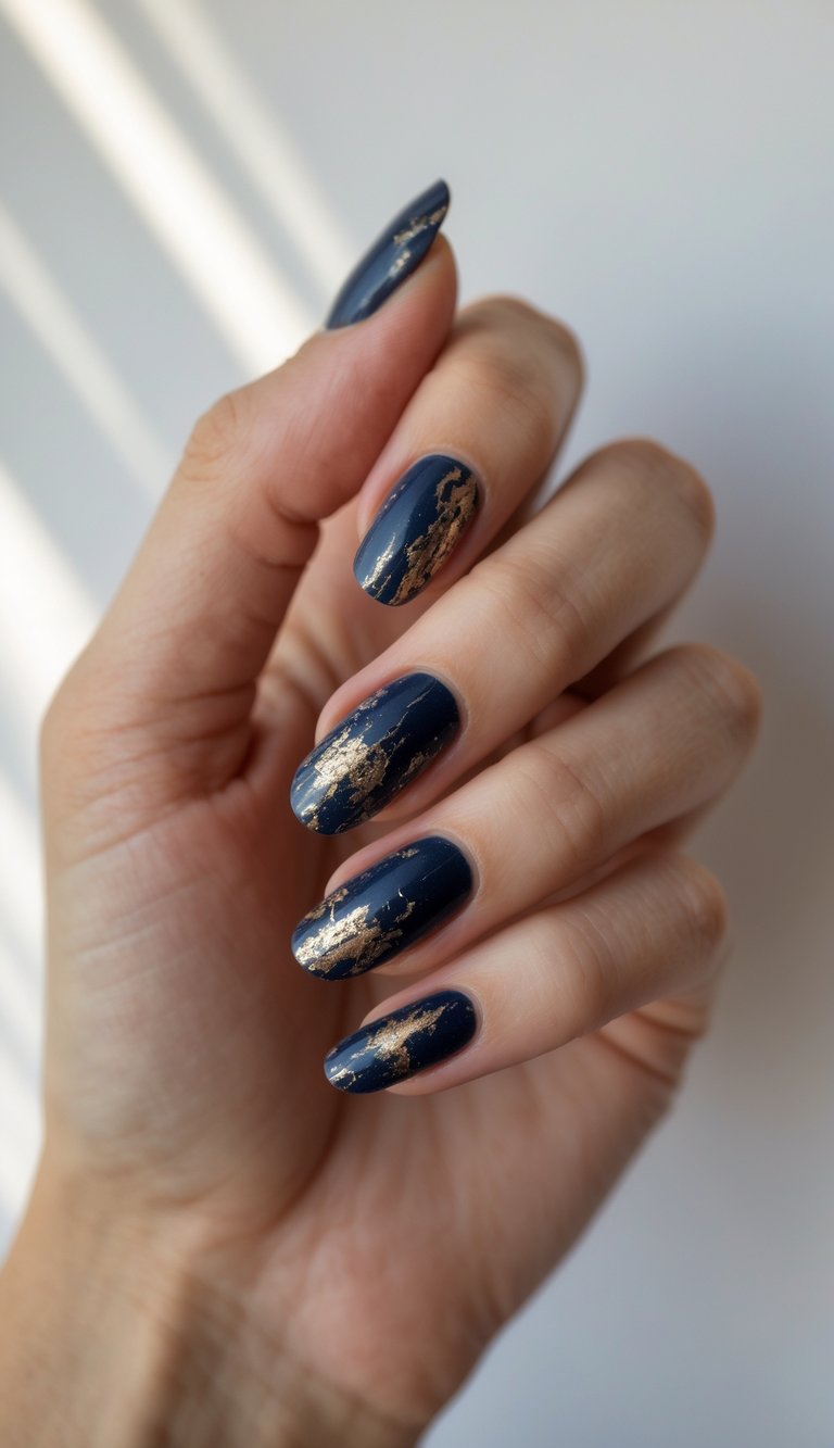 Close-up of one hand with navy blue nails featuring metallic flecks and textured nail art on a white background.