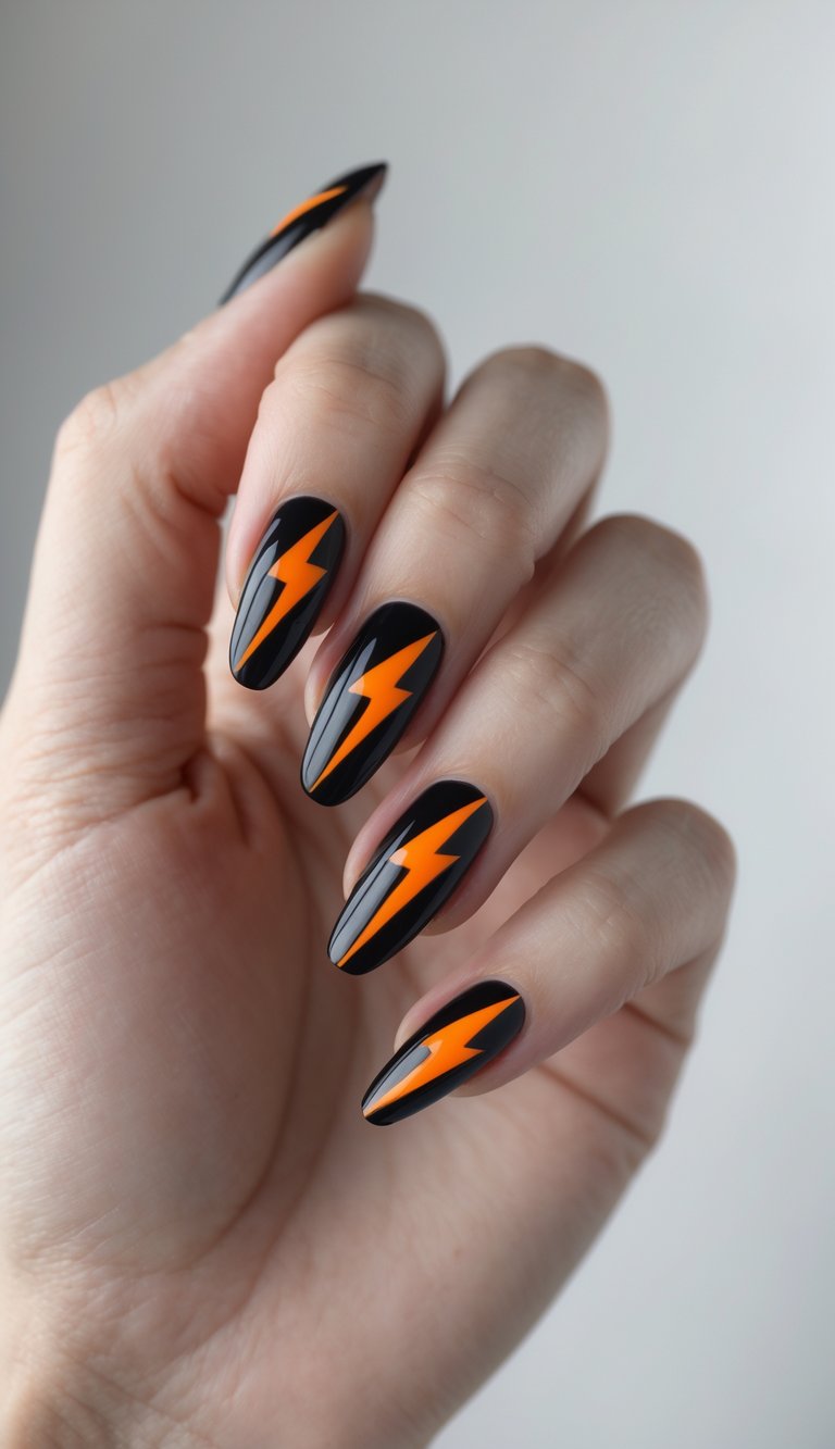 Close-up of one hand with black nails decorated with bright orange lightning bolt designs against a white background.