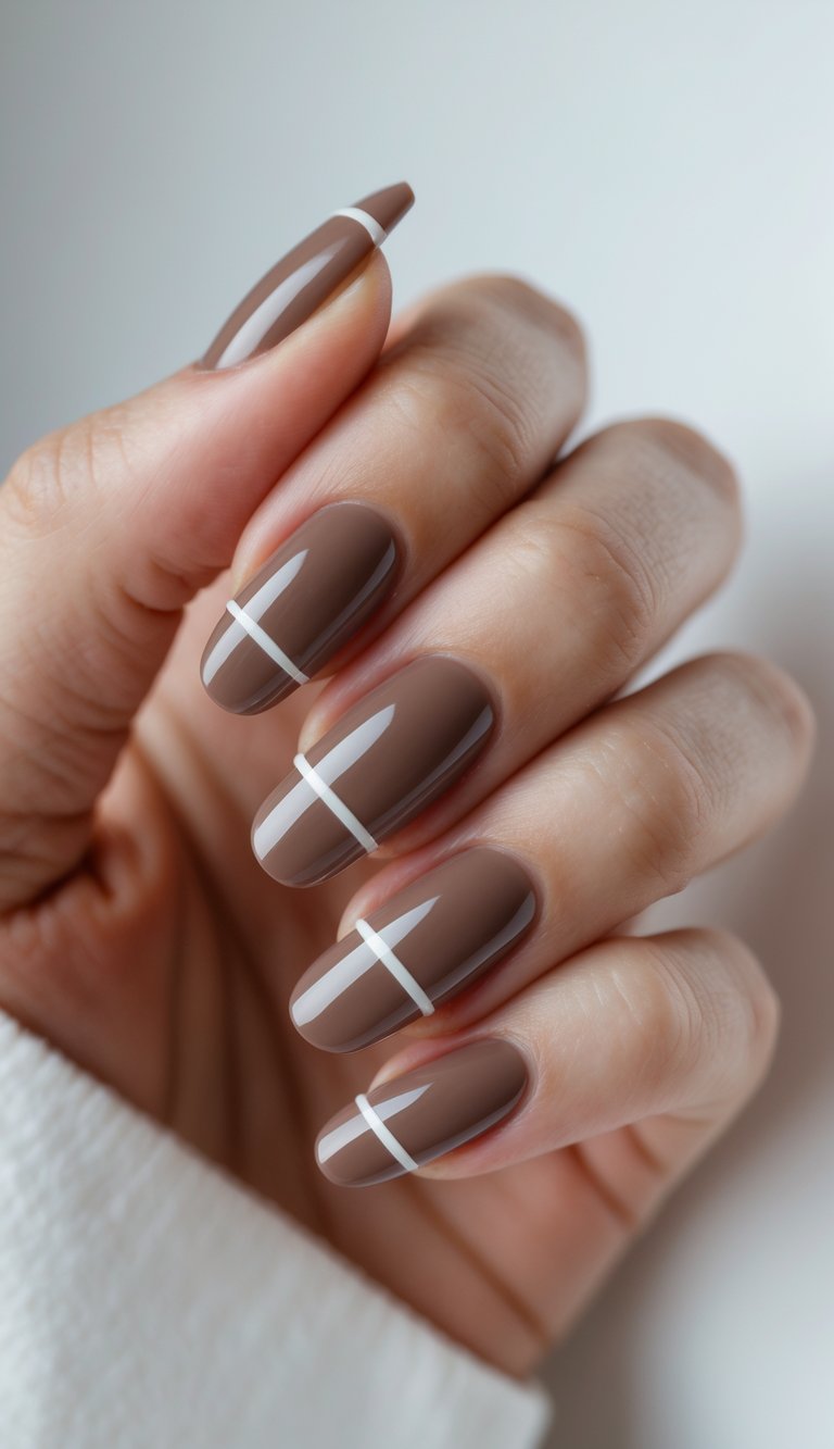 Close-up of one hand showing mocha-colored nails with white line designs against a white background.