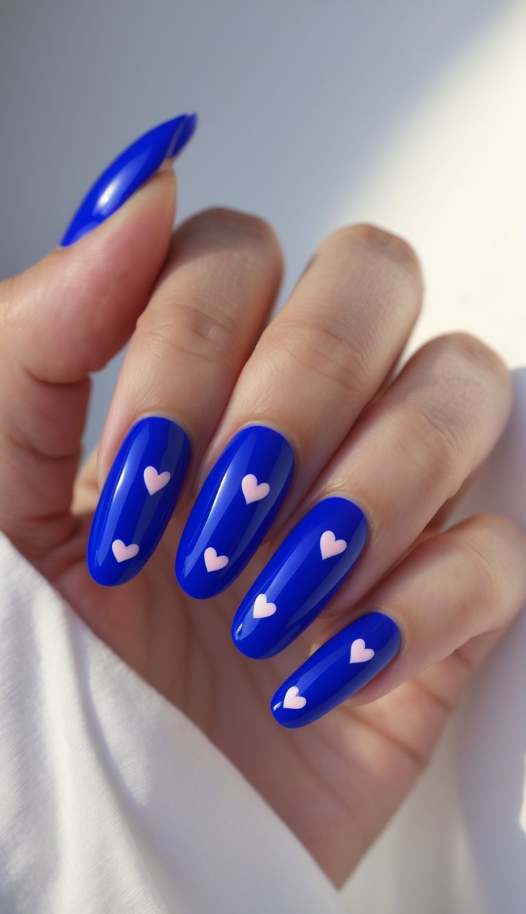 Tiny light pink hearts pop against these long royal blue nails