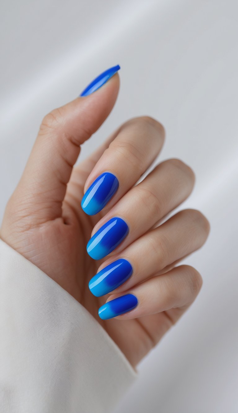 Close-up of one hand showing nails with French manicure and cobalt blue tips against a white background.