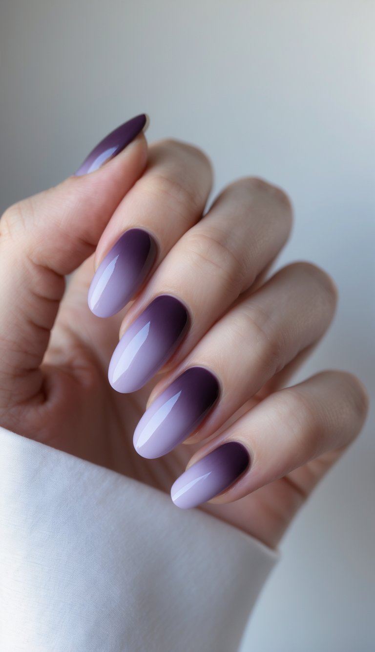 Close-up of one hand with neatly manicured nails featuring a soft gradient from plum to lilac on a white background.