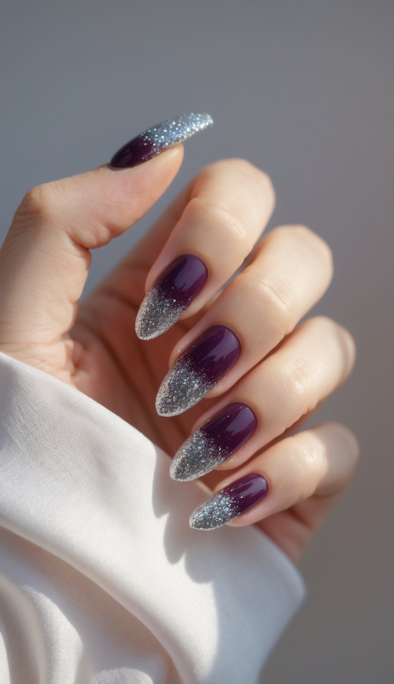 Close-up of one hand with plum-colored nails and silver glitter tips against a white background.