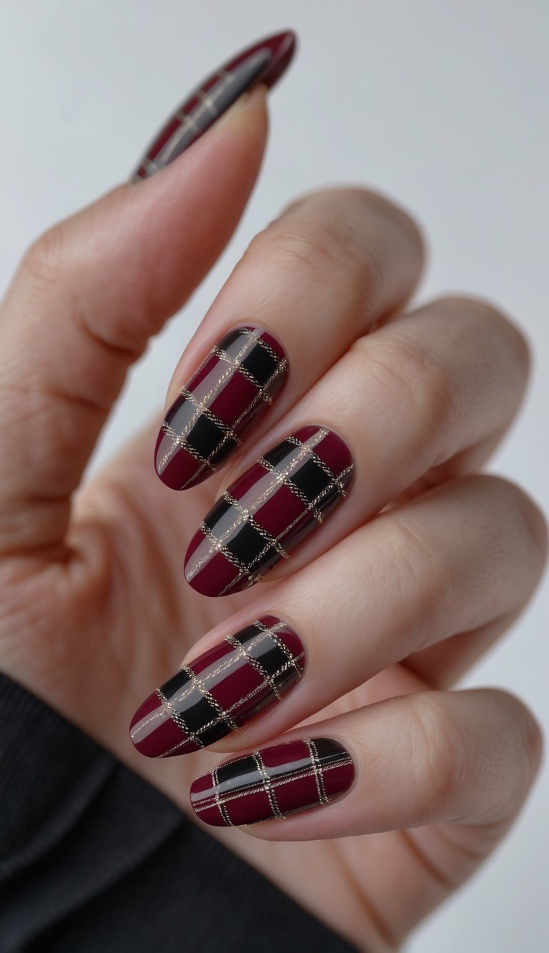Close-up of one hand with deep burgundy and black tartan plaid nail art on each nail against a white background.