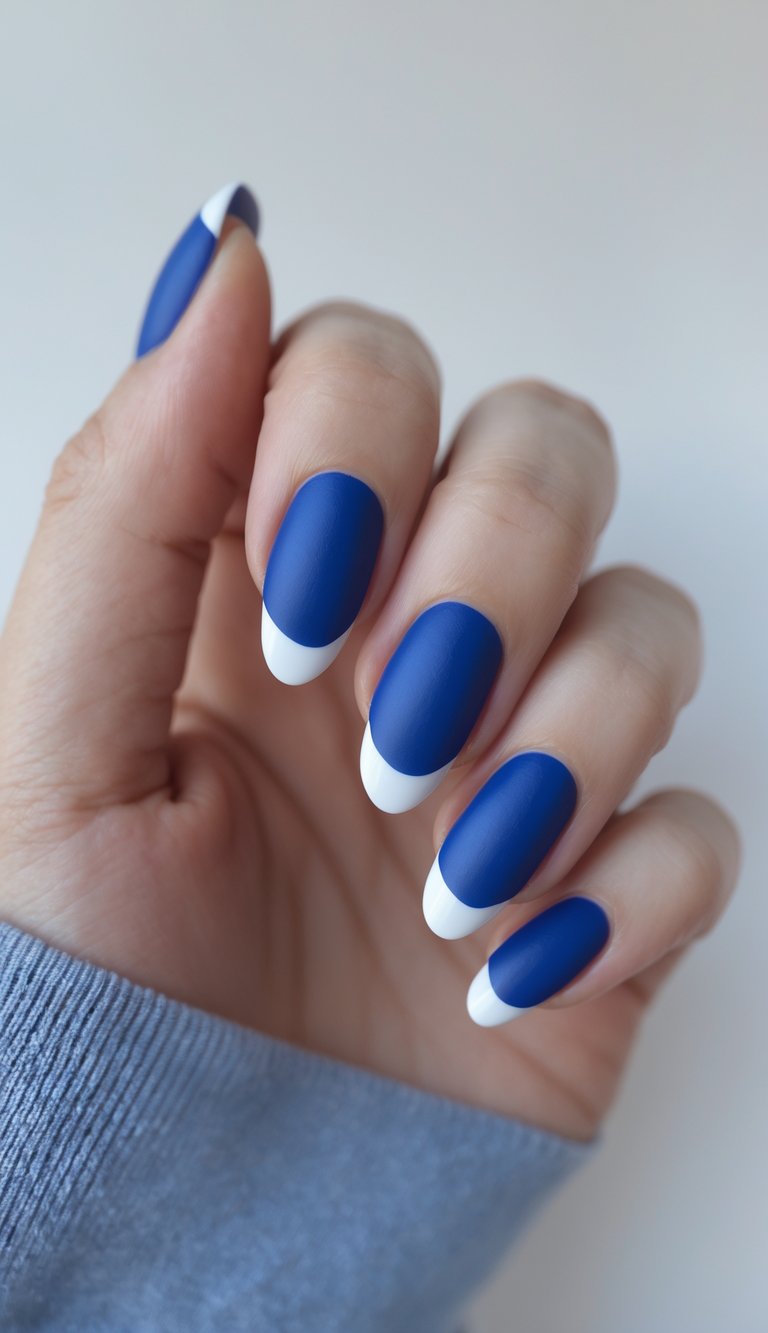Close-up of one hand with royal blue nails featuring matte bases and glossy tips against a white background.