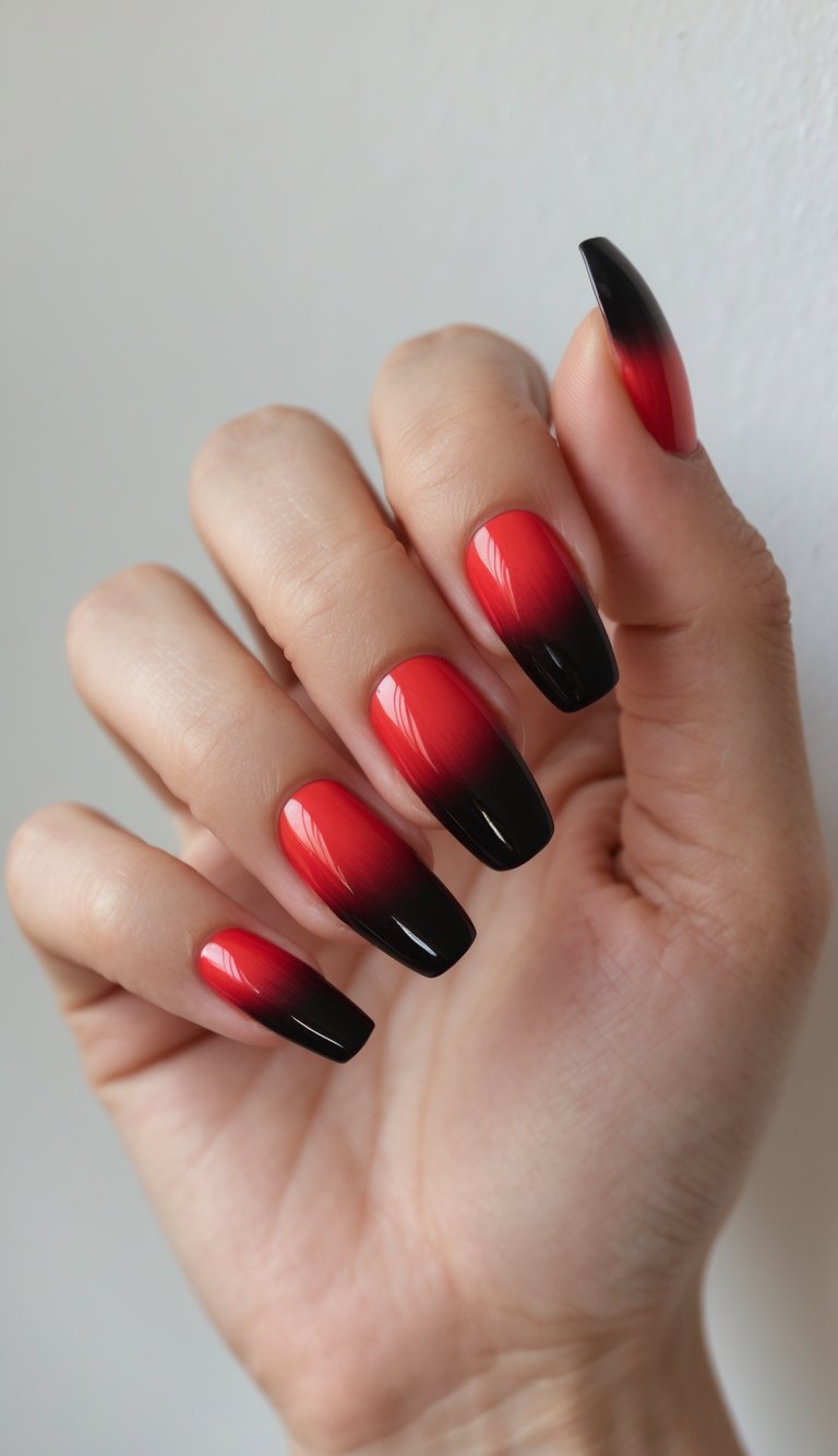 Close-up of one hand with nails painted in a red to black gradient ombre design against a white background.