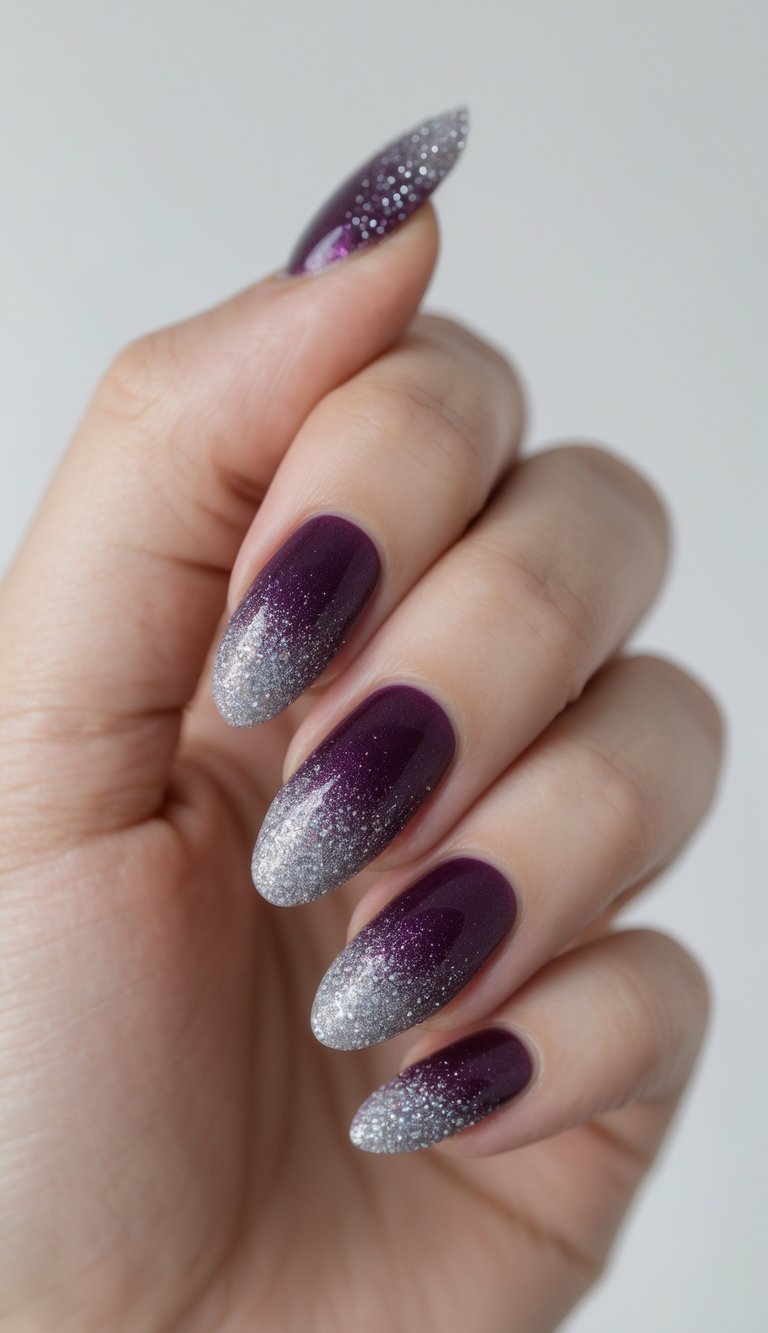 Close-up of one hand with plum-colored nails featuring a glitter gradient on a white background.