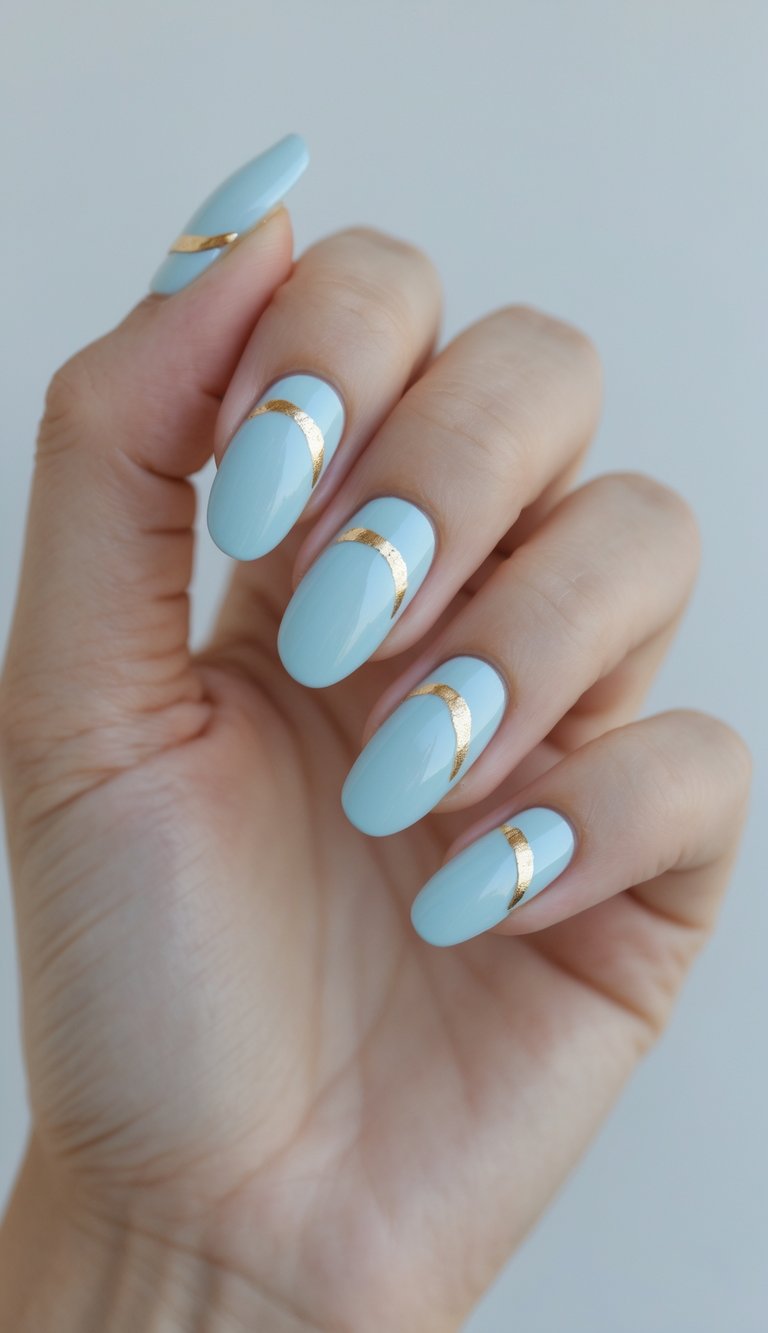 Close-up of one hand showing glossy baby blue nails with simple gold designs on a white background.