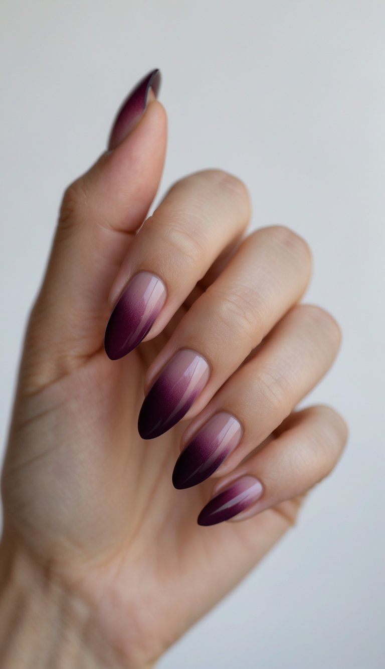 Close-up of one hand with neatly manicured nails featuring a plum to burgundy gradient and simple nail art on a white background.