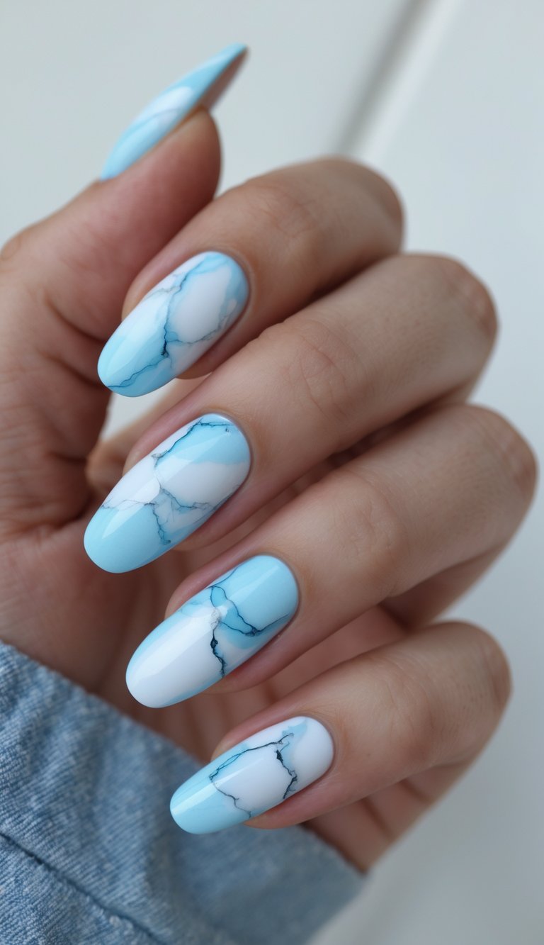 Close-up of one hand showing baby blue nails with marble patterns on a white background.