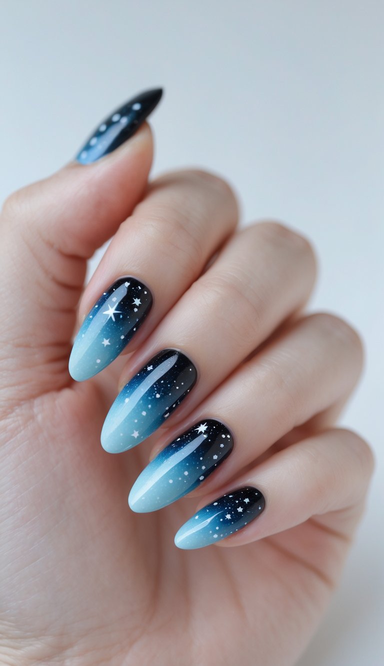 Close-up of one hand with nails painted in a galaxy ombré design fading from black to light blue with star details on a white background.