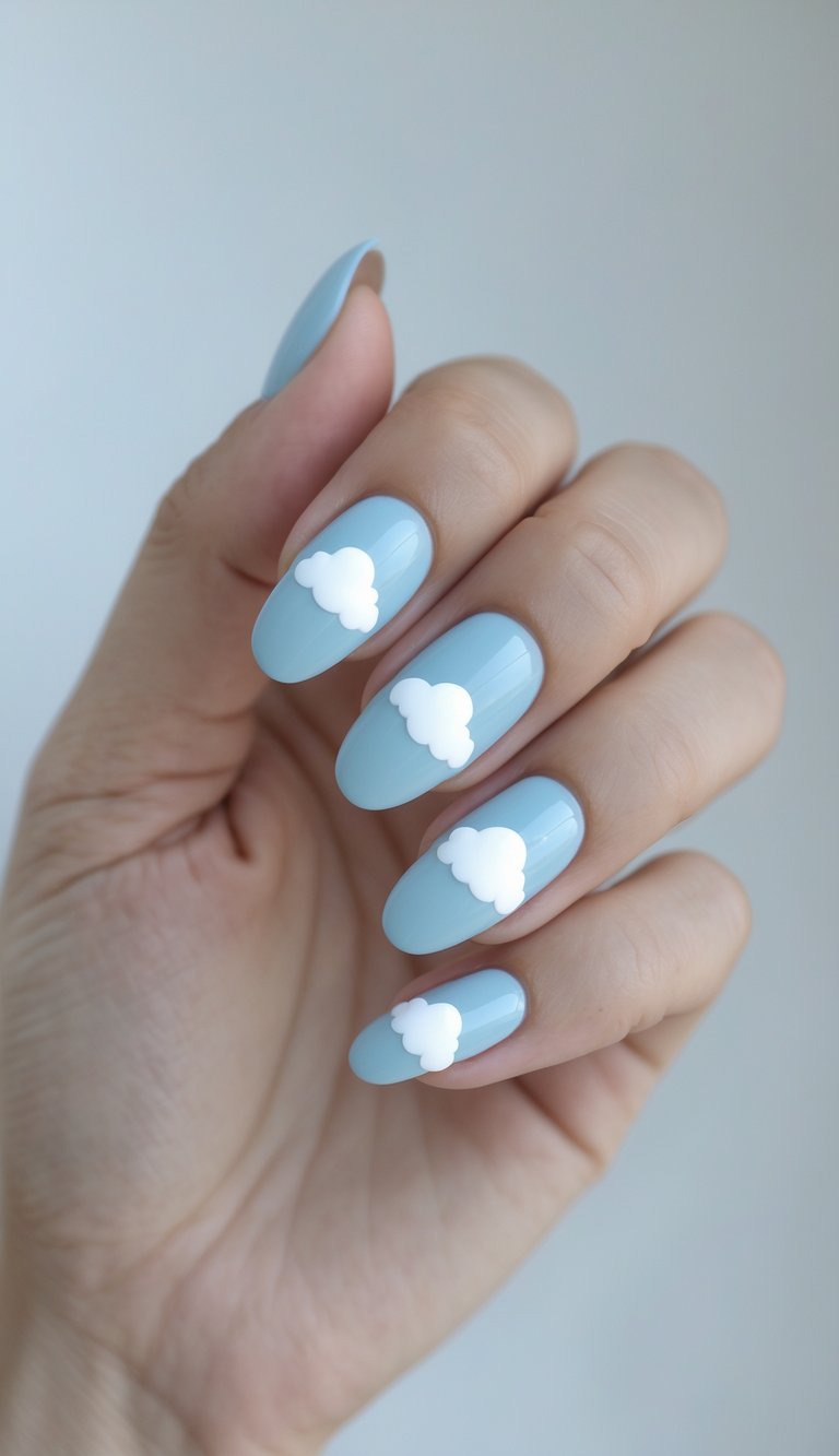 Close-up of one hand showing baby blue nails with white cloud designs on a white background.