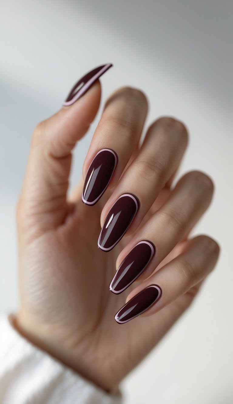 Close-up of one hand with wine-colored French tip manicured nails against a white background.