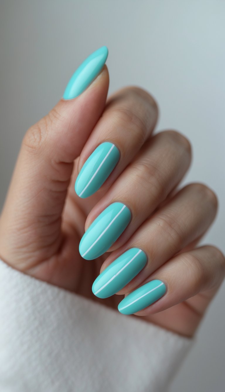 Close-up of one hand with aqua-colored French manicure nails featuring thin white lines on a white background.