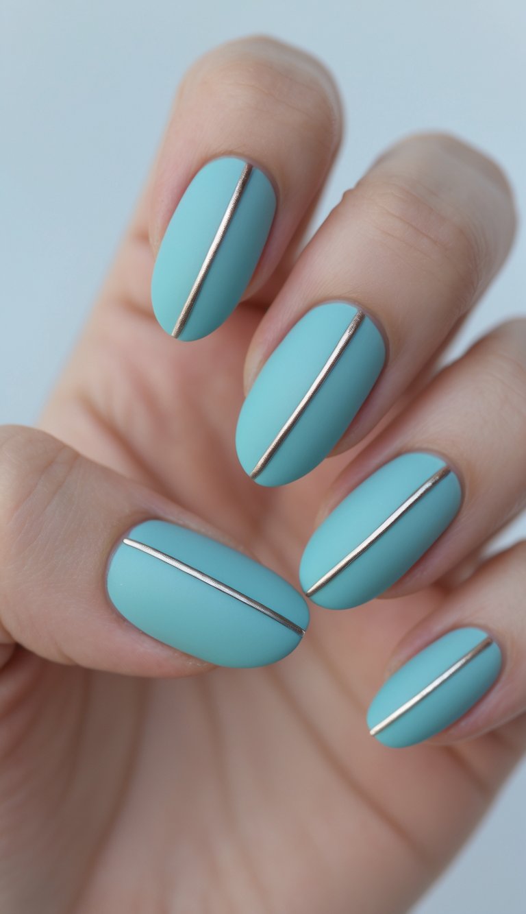 Close-up of a hand with aqua-colored nails featuring a thin silver line down the center of each nail against a white background.