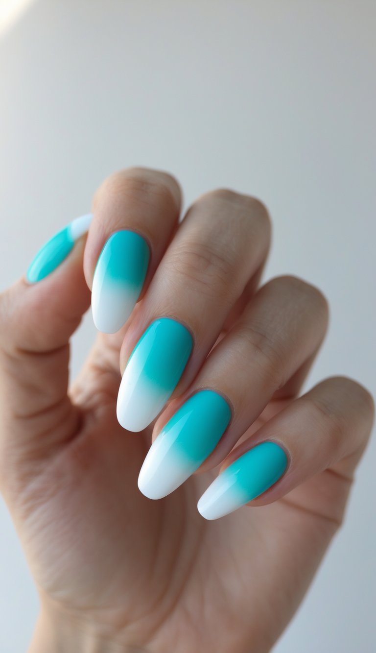 Close-up of one hand with turquoise-to-white gradient nails against a plain white background.