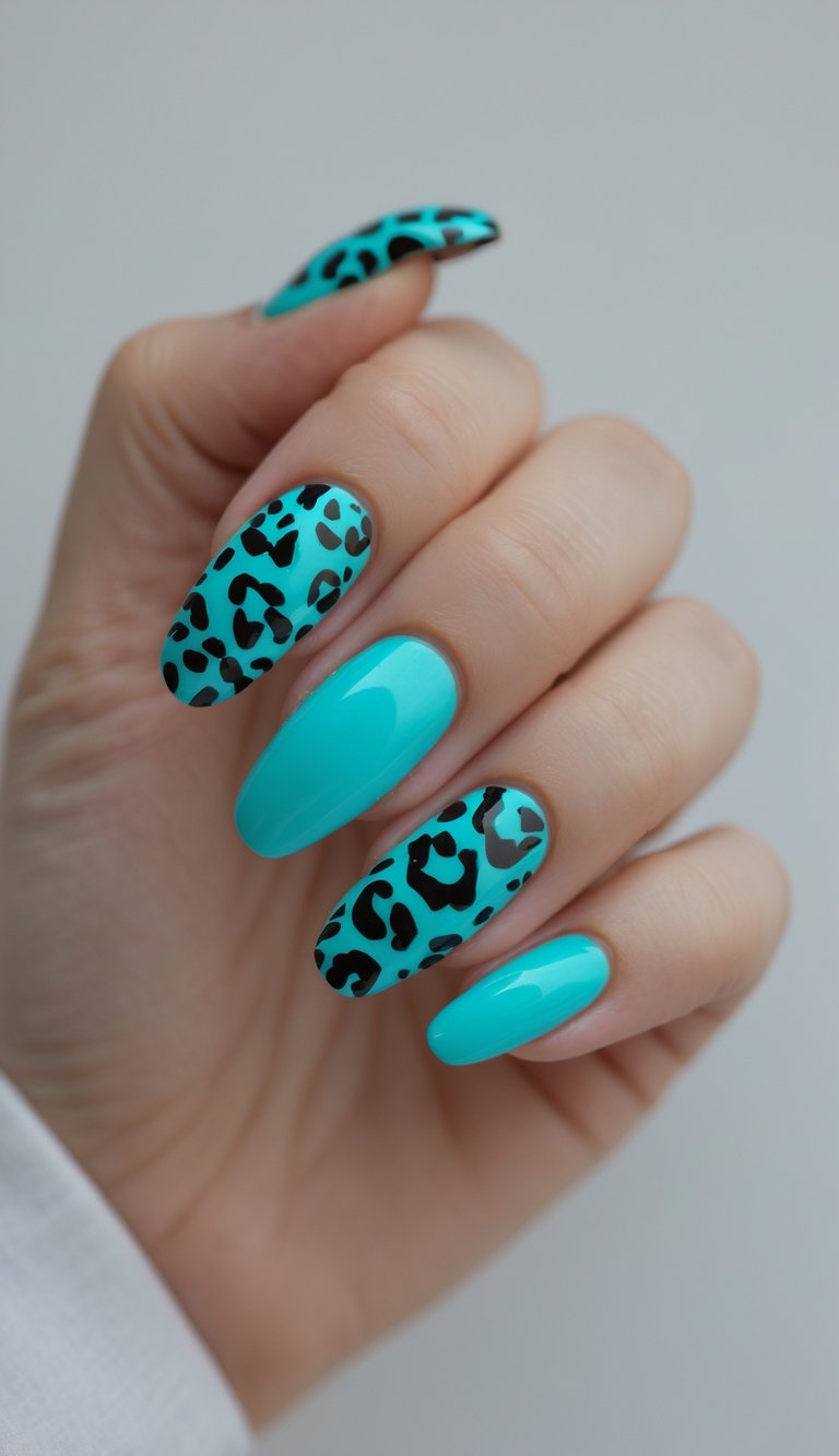 Close-up of one hand with turquoise and leopard print nail art on a white background.