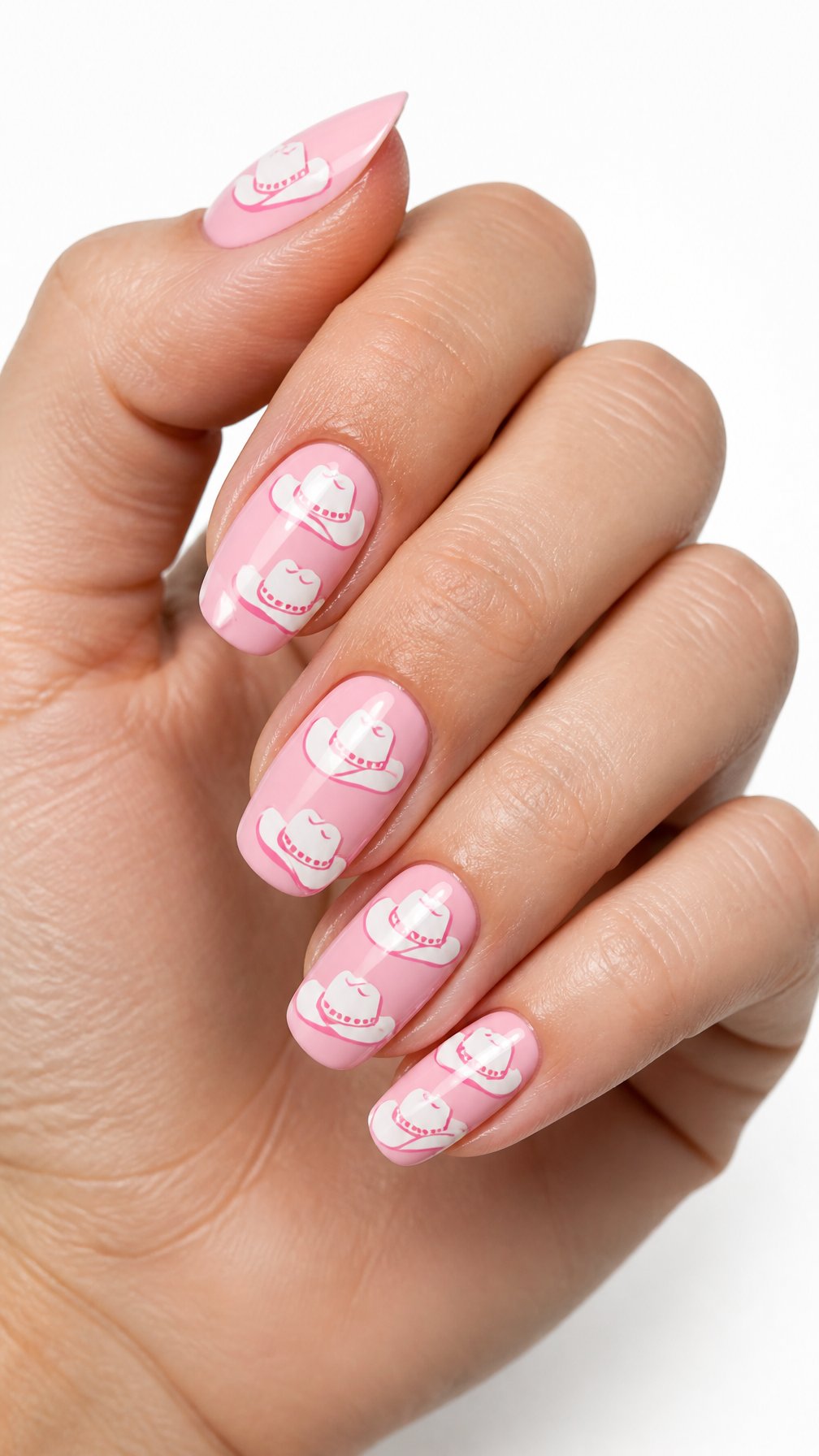 A single hand with pink-and-white cowboy hat designs painted on its nails against a white background.