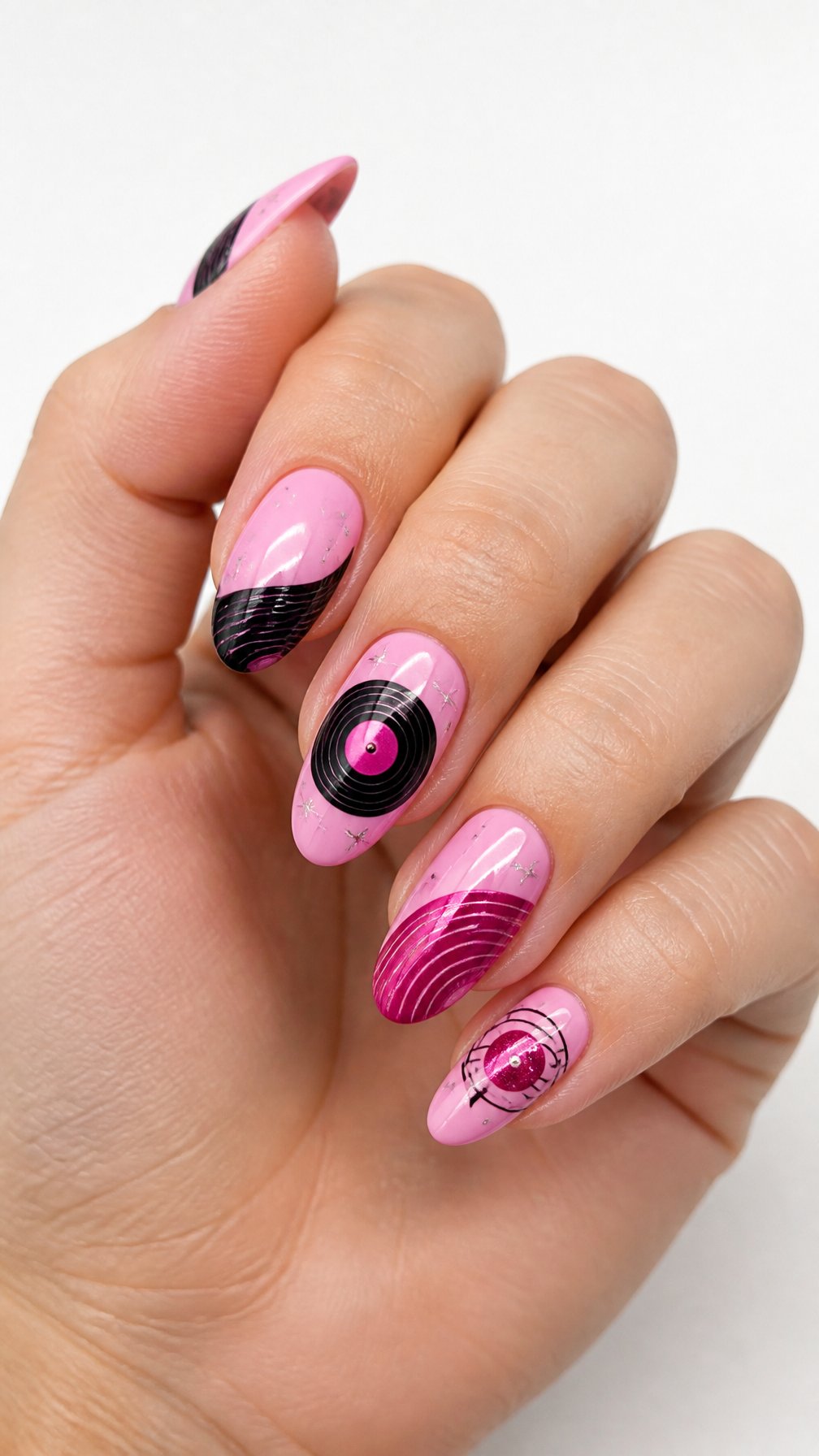 A single hand displays glossy pink nails decorated with miniature vinyl record designs against a white background.