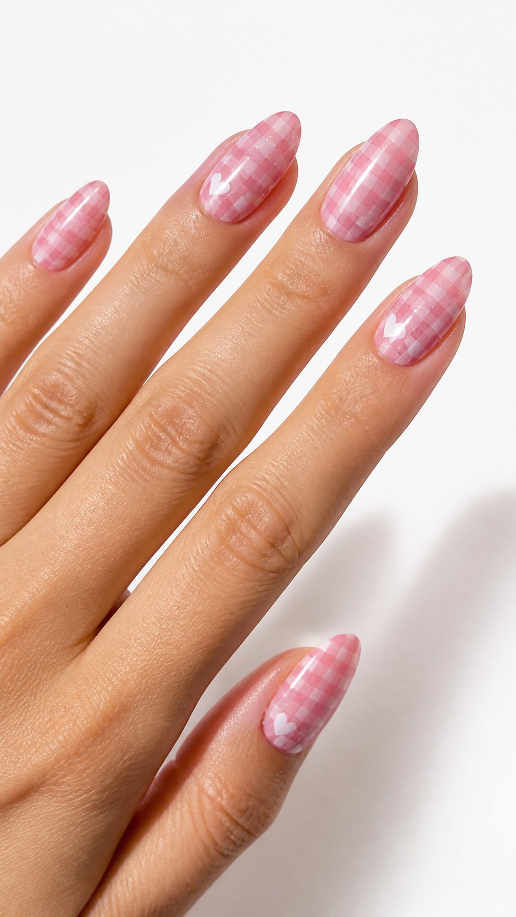 A single hand displays pink gingham patterned nails against a white background.