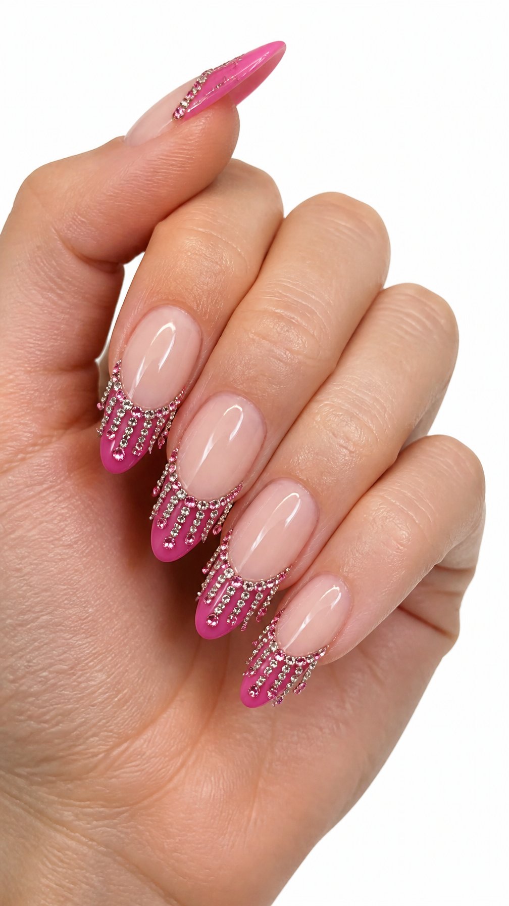 A single hand with glossy pink nails decorated with sparkling rhinestone fringe tips rests against a white background.