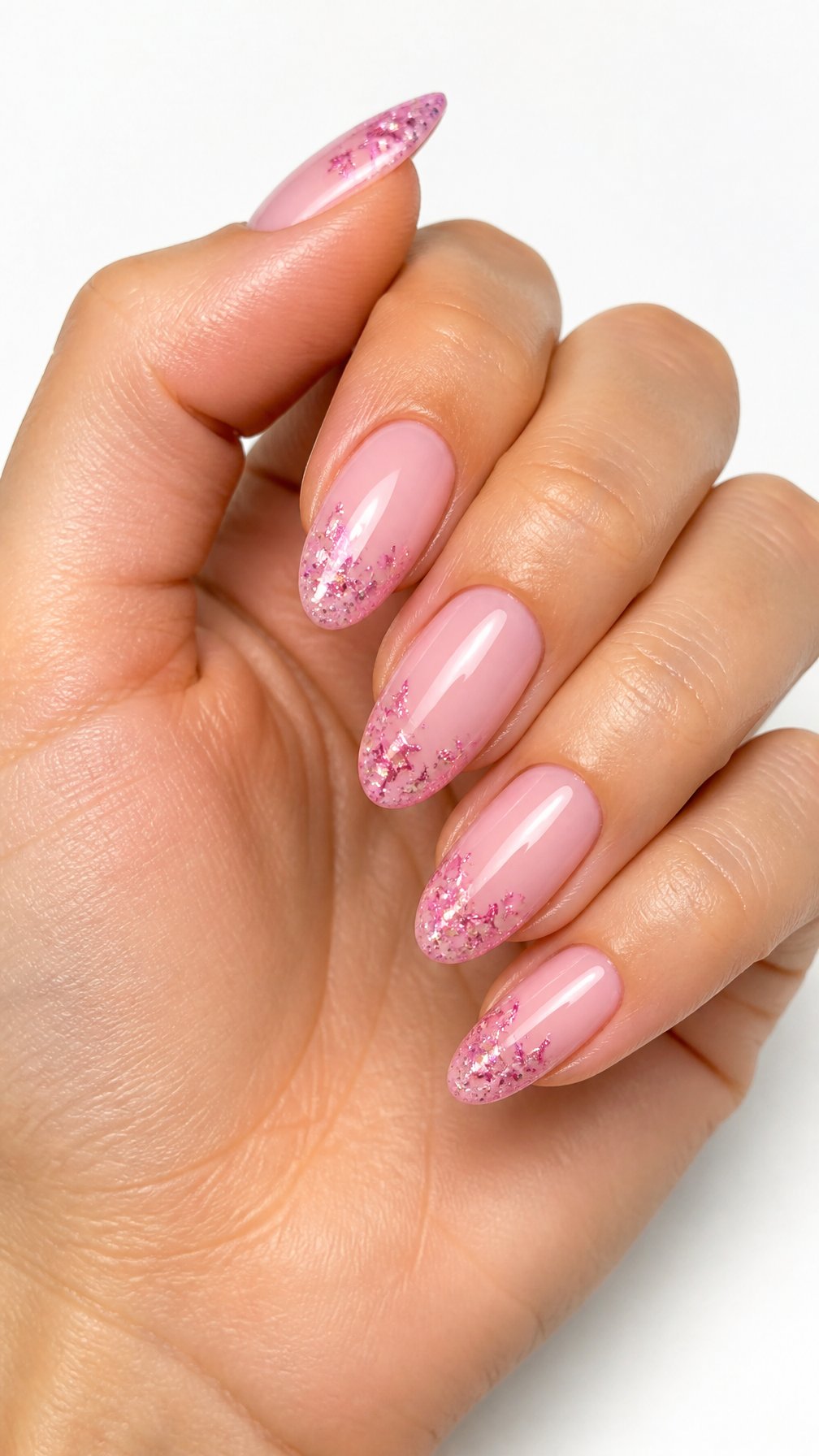 A single hand with glossy pink nails decorated with sparkling pink star tips against a white background.